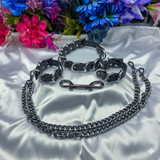 Metallic chain dog collar and leash set on a white fabric background with flowers.